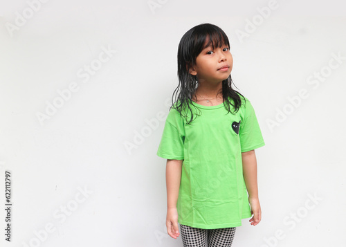 A cute smiling girl standing while looking at camera with curious gesture