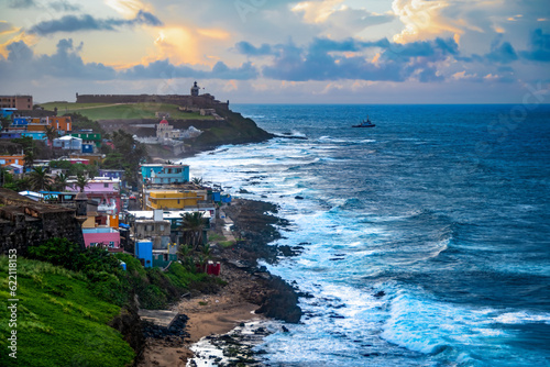 Waves crash against the coastline of San Juan, Puerto Rico during sunset. photo