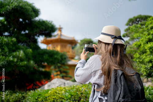 Photography Asian tourist, cute woman with long hair are traveling in Hong Kong along with map and her camera with fun on her holiday, A temple Nan Lian Garden in Hong Kong, concept travel