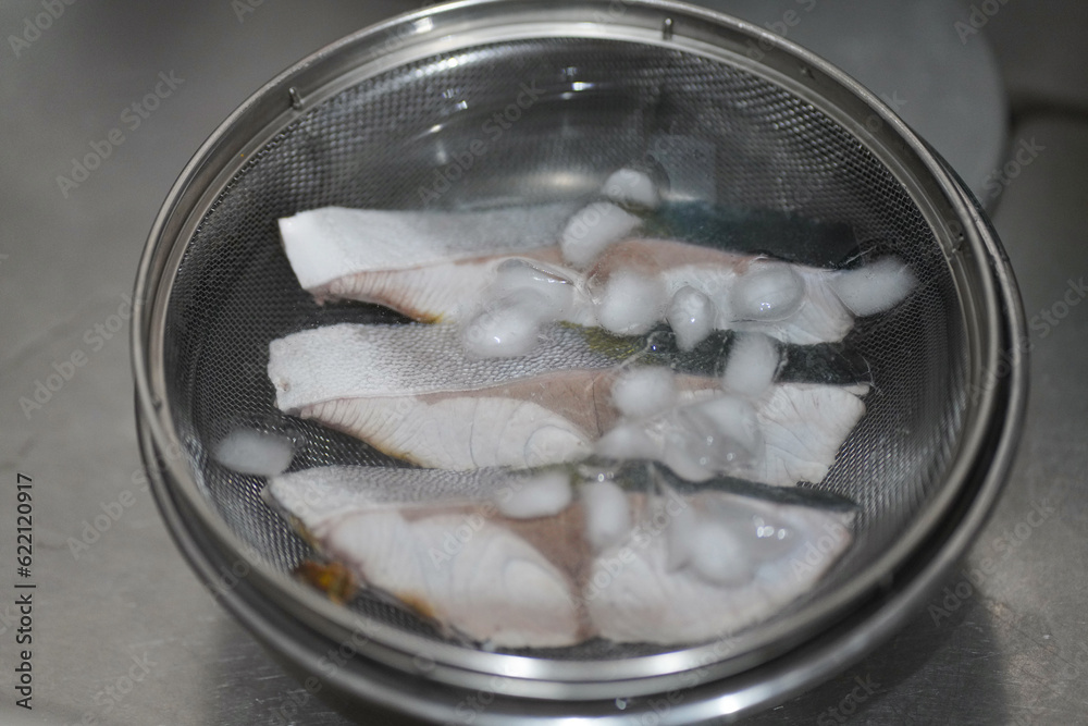 下茹でしたブリを氷水で冷やす様子 下茹でしたブリを氷水で冷やす様子