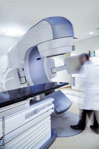 X-ray linear accelerator tomography machine with blurred doctors figure in hospital. photo