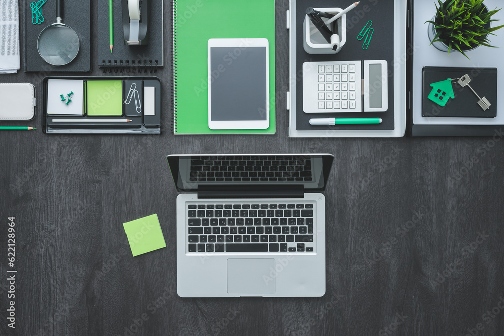 Flat lay corporate business desktop with office accessories and a laptop on a dark background Flat lay corporate business desktop with office accessories and a laptop on a dark background