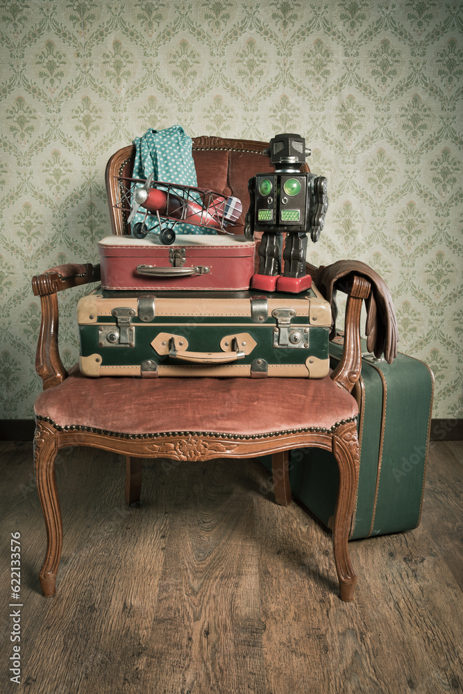 Family holiday packing with vintage suitcases and toys on elegant red velvet armchair.