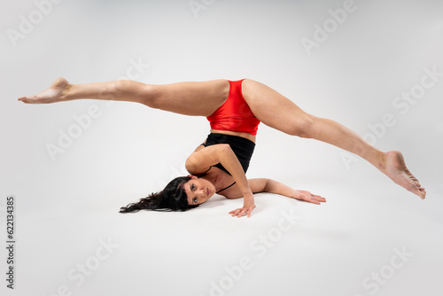 Fashion. Beautiful portrait of a young woman isolated on a gray and white studio. Having fun, happy, throughout. Dance, go crazy, have fun. girl with black top and red shorts