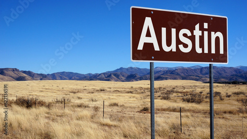 Austin road sign with blue sky and wilderness