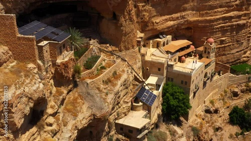 Aerial: Drone Panning Of Solar Panels On Famous Monastery At Cliff During Sunny Day - Judaean Desert, Israel photo