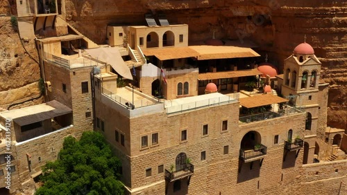 Aerial: Drone Descending Over Famous Monastery On Cliff During Sunny Day - Judaean Desert, Israel photo