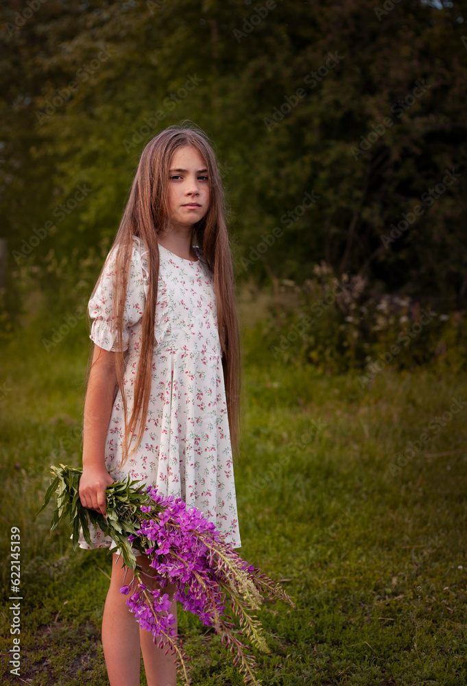 Portrait of a little girl with a bouquet of wildflowers
