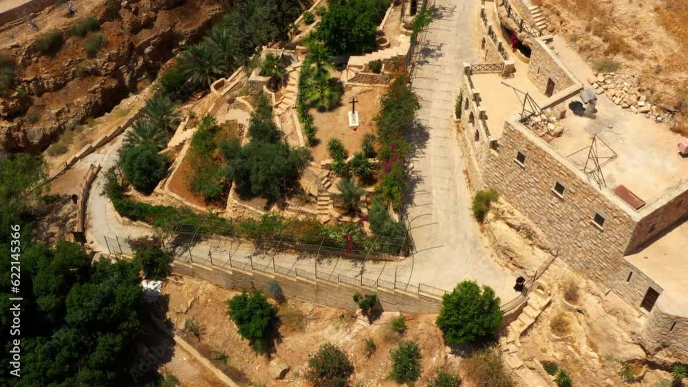 Aerial: Drone Forward Tilt Up Shot Of Popular Monastery On Cliff Near Mountains During Sunny Day - Judaean Desert, Israel Aerial: Drone Forward Tilt Up Shot Of Popular Monastery On Cliff Near Mountains During Sunny Day - Judaean Desert, Israel