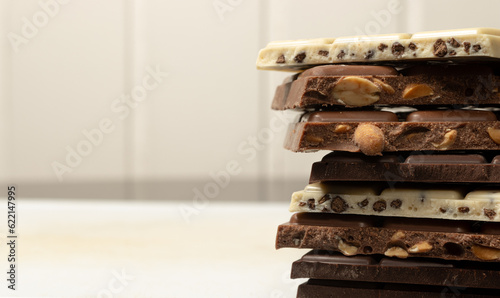 Pieces of white chocolates, with peanuts and 75% cocoa in close up. Copyspace.