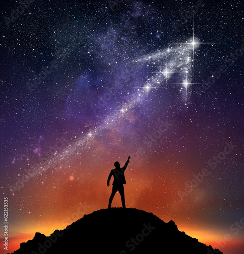 Businessman on a mountain indicate an arrow with stars