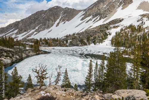 frozen lake and snow covered mountains during spring thaw