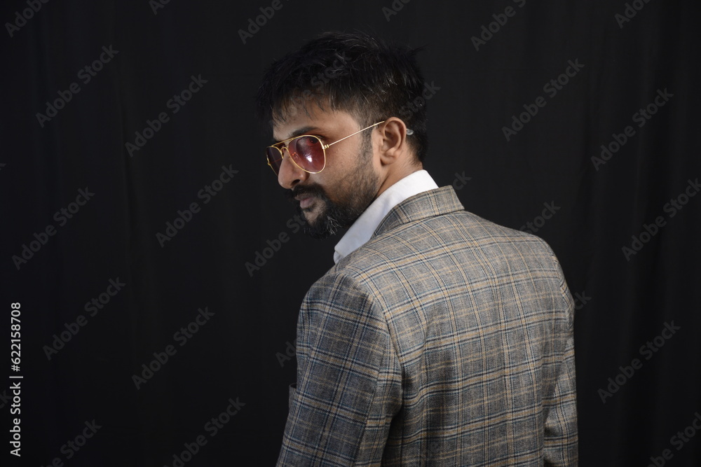 Portrait of happy corporate dressed up person in suit and wearing specs portraying different moods. Low key shoot of bearded office man well suited. Black background. Portrait of happy corporate dressed up person in suit and wearing specs portraying different moods. Low key shoot of bearded office man well suited. Black background.