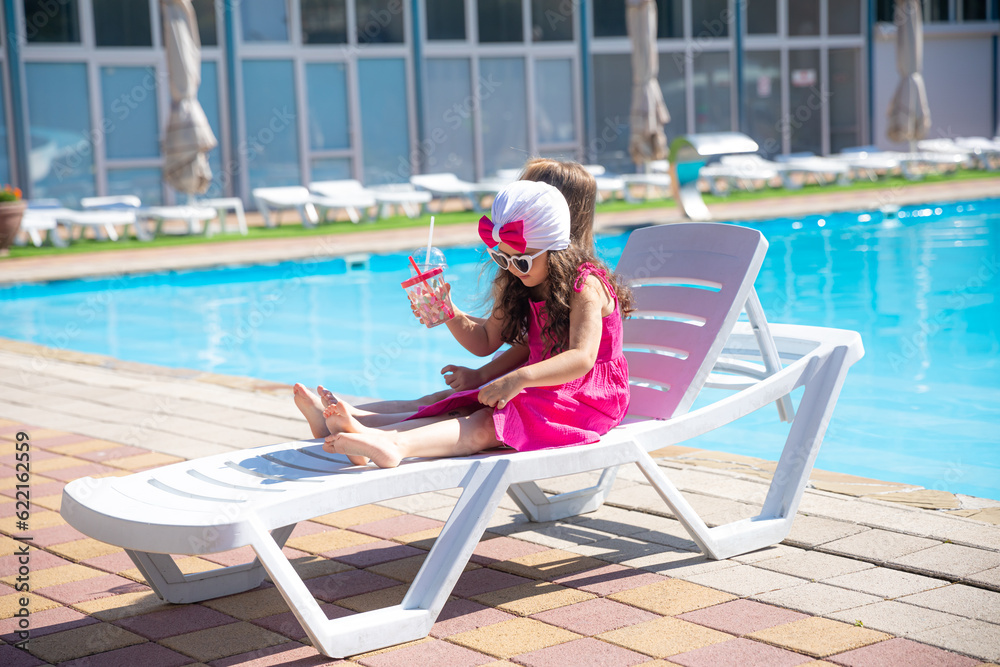 Summer season. Children cute little girls lying by pool. Summer vacation concept