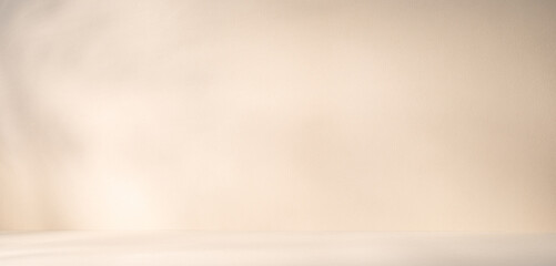 A light beige product presentation background with sunlight beams and shadows on it