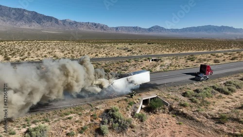 Aerial semi truck dangerous trailer fire desert highway slide. Interstate highway in desert of Arizona and Nevada. Transporting fresh meat. Fire and smoke destroys cargo and HAZMAT pollution.