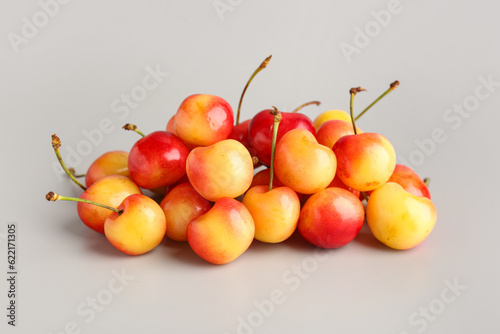 Heap of sweet yellow cherries on grey background © Pixel-Shot