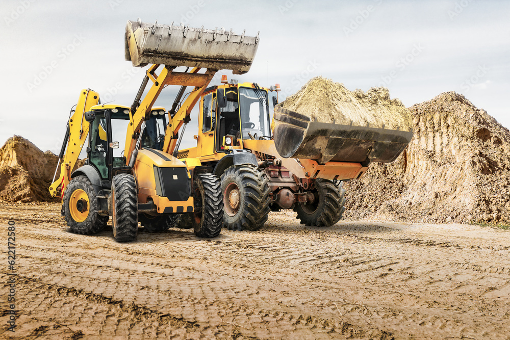 Modern construction machinery at a construction site in a quarry. Powerful modern equipment for earthworks. Rental of construction equipment. Excavator, dump truck, bulldozer, loader. Modern construction machinery at a construction site in a quarry. Powerful modern equipment for earthworks. Rental of construction equipment. Excavator, dump truck, bulldozer, loader.