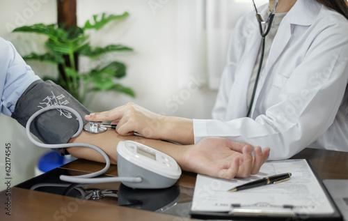 The female doctor measured blood pressure, the patient examined the heartbeat, and sat down to talk about health care closely. health care concept