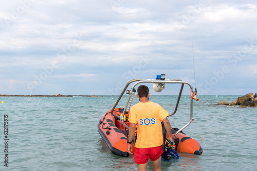 Lifeguard approaching to a rescue boat on the sea © carles