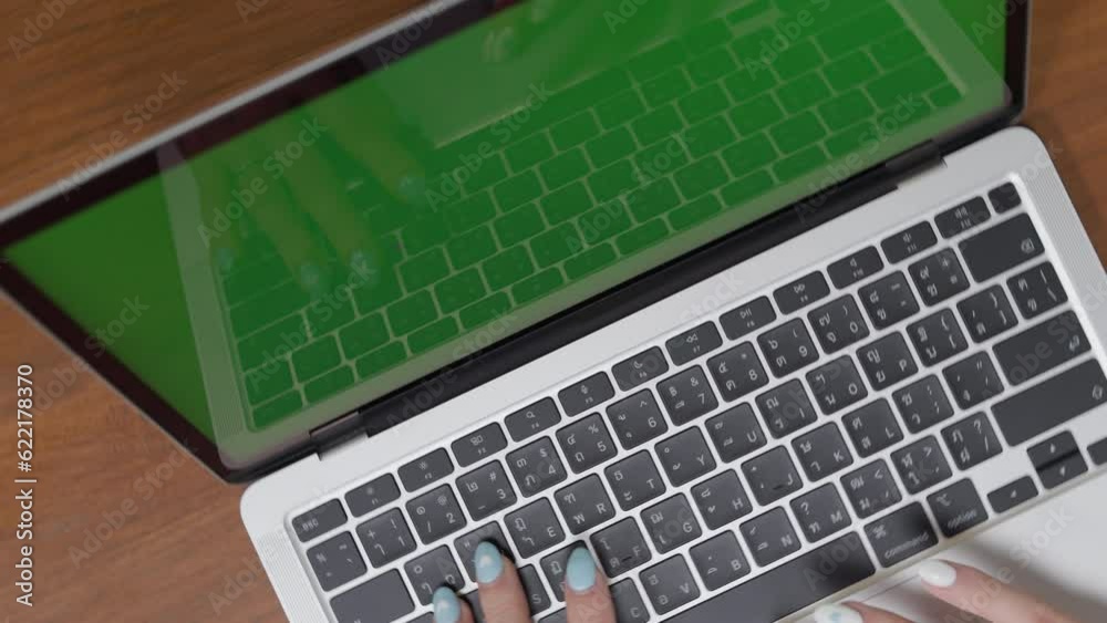 With a camera rotation, the close-up shot focuses on the hands of a professional businesswoman typing on a laptop keyboard at her home office work desk. green screen, chroma key With a camera rotation, the close-up shot focuses on the hands of a professional businesswoman typing on a laptop keyboard at her home office work desk. green screen, chroma key