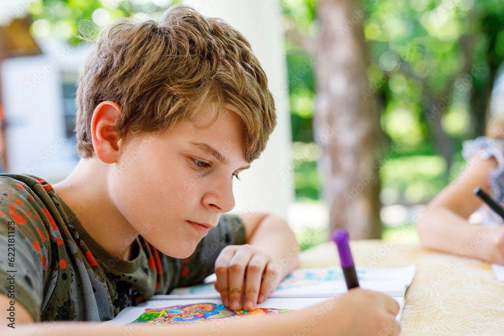 Preteen School Boy Drawing with Felt Pens. Back to School. Caucasian Little Schoolboy Drawing Picture at Home. Hobby, Education Concept. Preteen School Boy Drawing with Felt Pens. Back to School. Caucasian Little Schoolboy Drawing Picture at Home. Hobby, Education Concept.