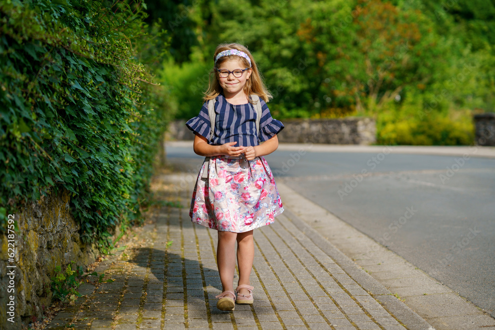 Little Preschool Girl on the Way to School. Healthy Happy Child Walking to Nursery School and Kindergarten. Smiling Child with Eyeglasses and Backpack on the City Street, Outdoors. Back to School. Little Preschool Girl on the Way to School. Healthy Happy Child Walking to Nursery School and Kindergarten. Smiling Child with Eyeglasses and Backpack on the City Street, Outdoors. Back to School.