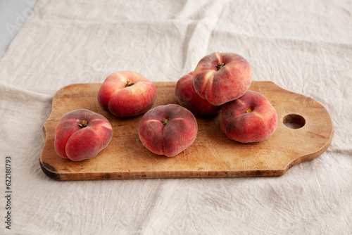 Organic Donut Saturn Peaches on a rustic wooden board, side view.