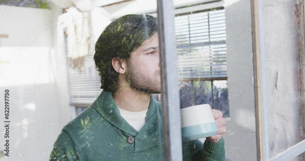 Caucasian man drinking coffee and looking out window at home, slow motion Caucasian man drinking coffee and looking out window at home, slow motion