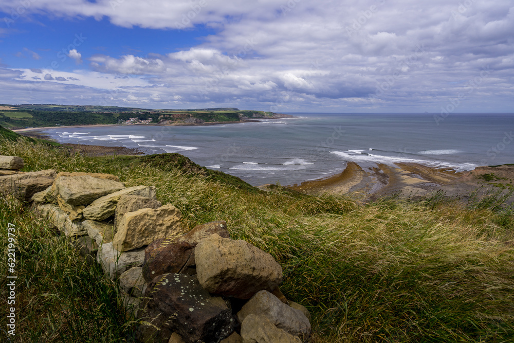 View from the Cleveland Way. This clifftop view is seen as you walk north approaching Kettleness, at the other side of the bay is the seaside village of Runswick Bay. View from the Cleveland Way. This clifftop view is seen as you walk north approaching Kettleness, at the other side of the bay is the seaside village of Runswick Bay.