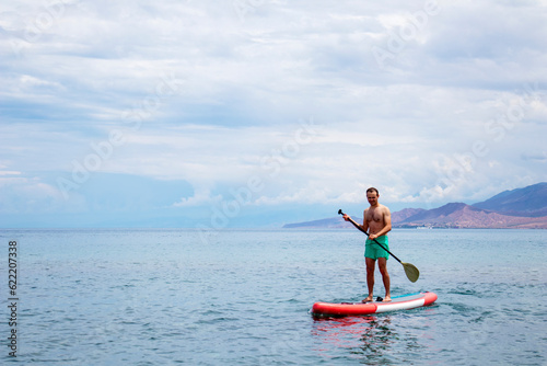 A man on a surfboard with a paddle