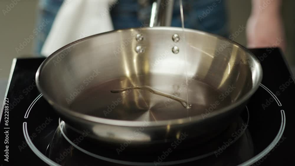 Super slow motion, restaurant cuisine, the process of cooking, chef at work, pour olive oil on a steel frying pan. Super slow motion, restaurant cuisine, the process of cooking, chef at work, pour olive oil on a steel frying pan.