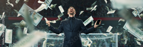 Emotional, lucky, excited businessman feeling success and win of many money on sports betting. 3D arena background. Concept of sport, fan, betting, finances, gambling, bookmaker, modern technologies