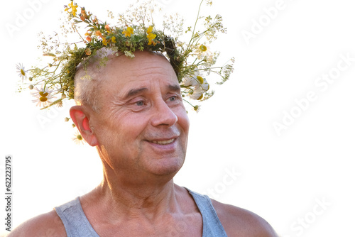 happy cool senior, satisfied funky hipster mature man of 60 years old smiles pretty in T-shirt and cute wreath wildflowers, daisies, natural crown on head, image faun, satyr, connection with nature