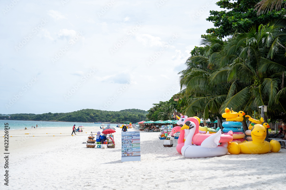 Fototapeta premium Image of tourists relaxing on weekends at white sandy beach with chairs, beach umbrellas and clear sky.