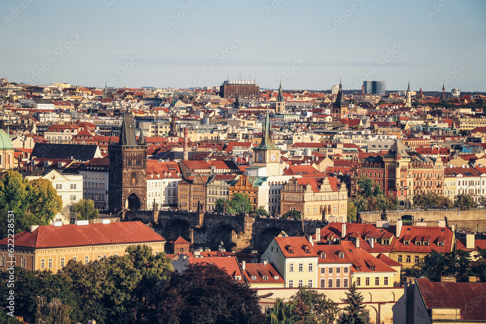 Old Town of Prague under the warm rays of the setting sun illuminating the rooftops of historic buildings in the capital of the Czech Republic. The centre of Prague