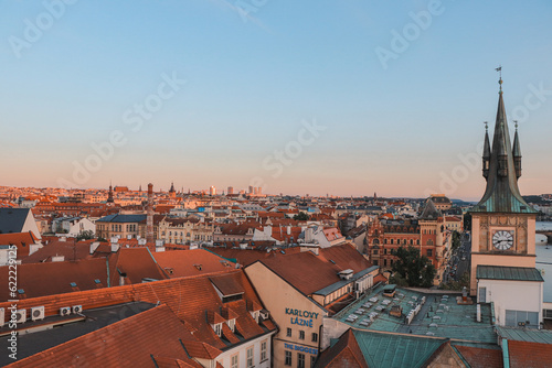 Old Town of Prague under the warm rays of the setting sun illuminating the rooftops of historic buildings in the capital of the Czech Republic. The centre of Prague