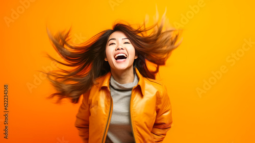 Photo Stunning, surprised Asian woman in midst of strong wind gust; an expression of unexpected astonishment on vivid studio background