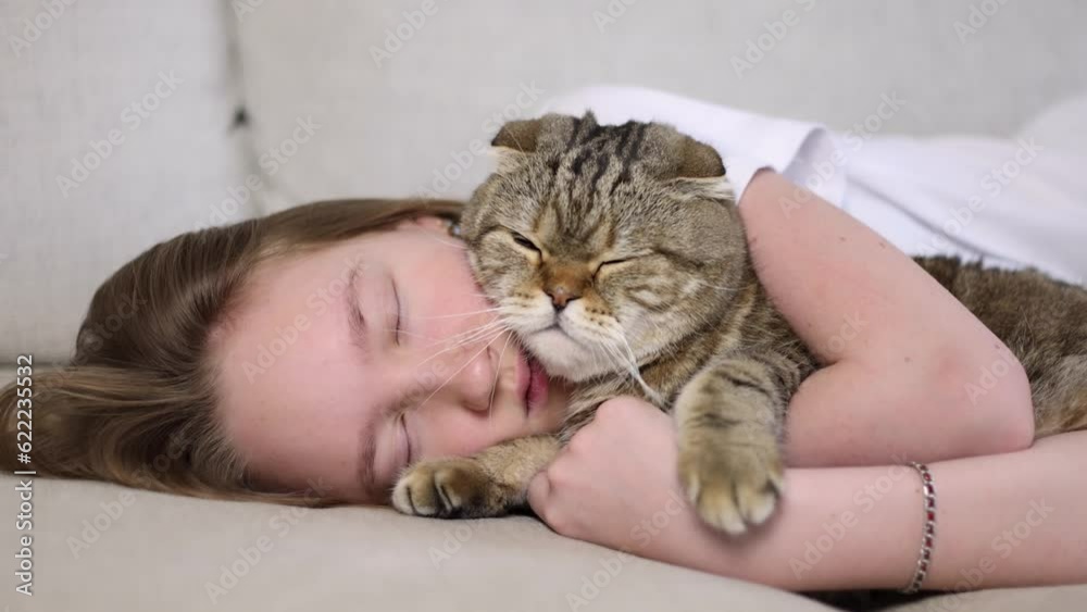 The girl is resting with the cat on the couch.