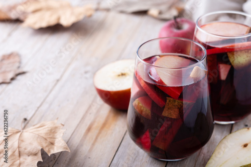 Autumn sangria with pear and apple on wooden table. Copy space