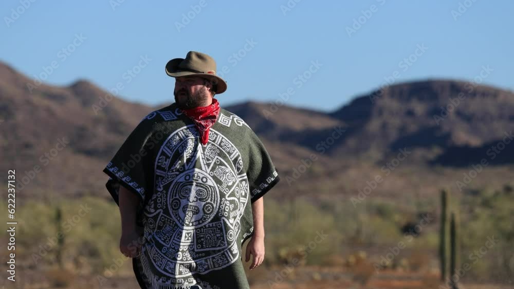 A Desperado man wearing a poncho, red bandanna, and a cowboy hat in the Sonoran Desert. Medium Shot. A Desperado man wearing a poncho, red bandanna, and a cowboy hat in the Sonoran Desert. Medium Shot.