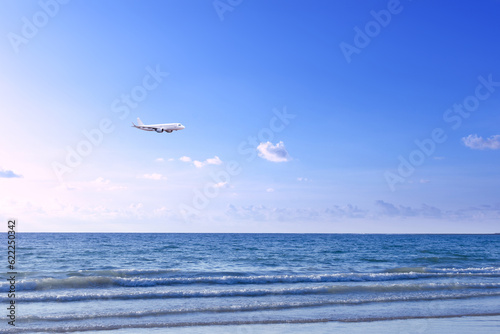 Commercial airplane above sea in summer season and clear blue sky over beautiful scenery sandy beach background  Concept business travel and transportation summer vacation travel.