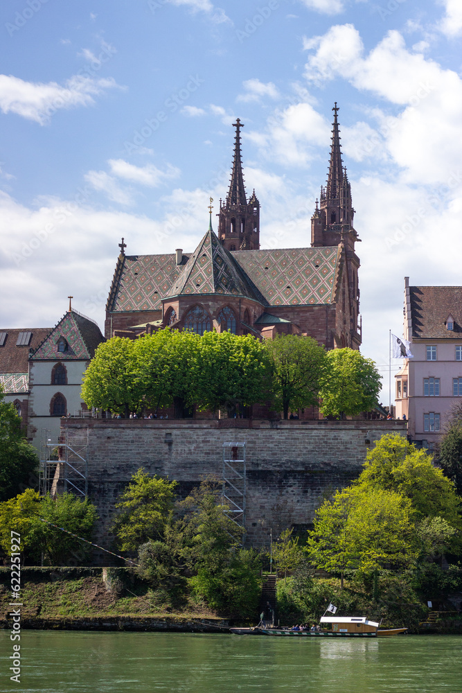Fototapeta premium View of the Rhine River at Basel City in Switzerland. Famous longest Rhine River. Travel and business destination at the cultural city. View of Cathedral of Basler Münster. Red sandstone Cathedral. 