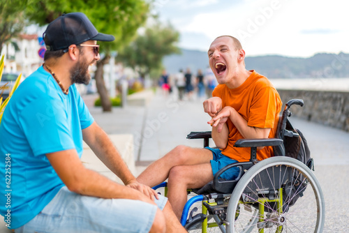 A disabled person in a wheelchair with a friend on summer vacation having fun laughing a lot