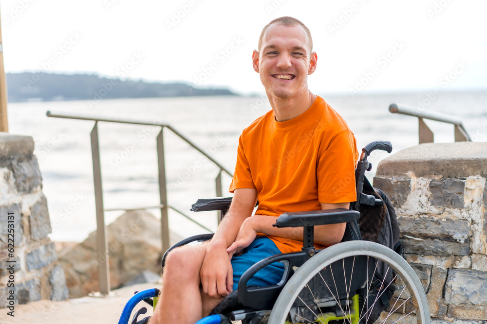 Portrait of a disabled person in a wheelchair at the beach on summer vacation smiling