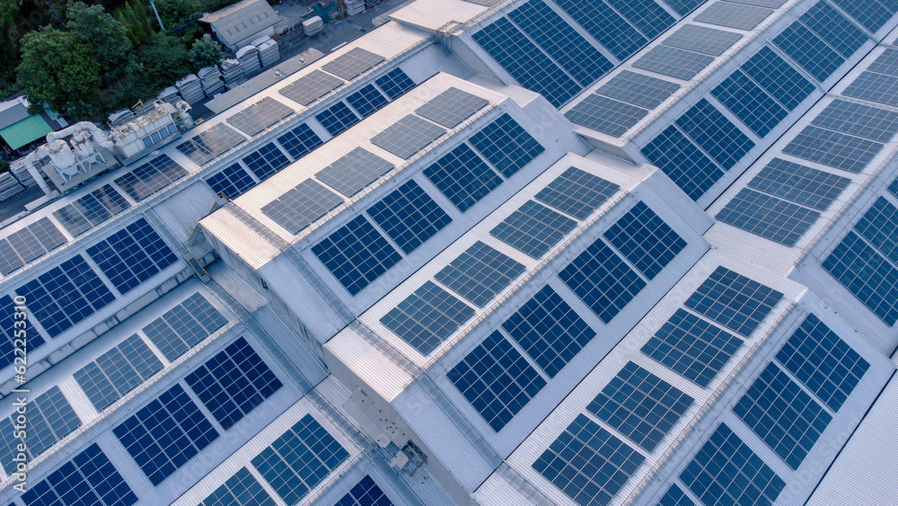 Aerial view of solar roof of the factory in eco environment. Solar Cells panel reflection with the sun and turn to blue color in industrial area. Concept of energy recycle.