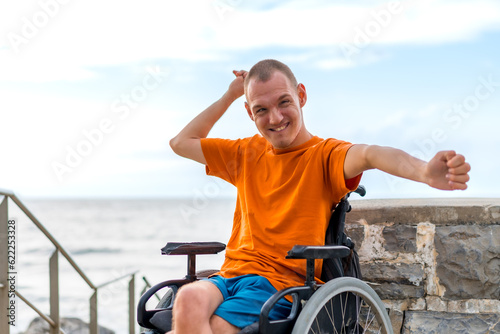 Portrait of a very cheerful disabled person in a wheelchair at the beach on vacation