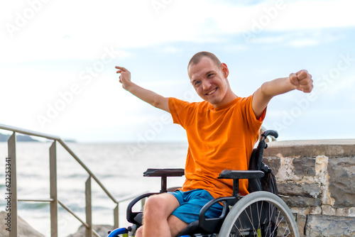 Portrait of a very cheerful disabled person in a wheelchair on vacation