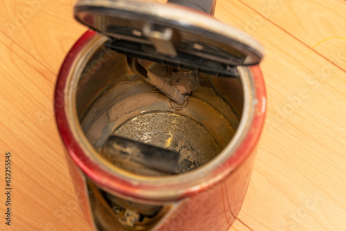  broken old used electric kettle with scale and lime deposits photo