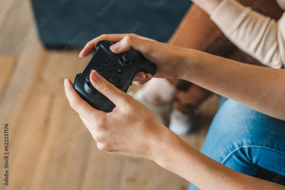 Crop gamer with gamepad playing video game